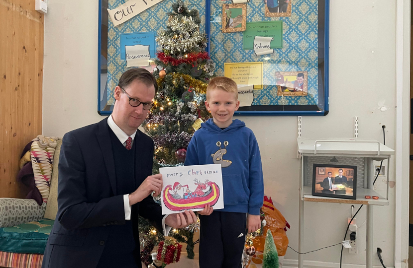 Tom Randall MP with Blake at Netherfield Primary School holding the running-up entry he designed alongside a framed photo of the Prime Minister with Blake’s design.