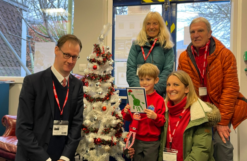Tom Randall MP with the Ruari, age 5, holding the winning entry he designed alongside his mother and grandparents at Westdale Infant School.