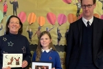 Tom Randall MP with the Killisick Junior School Headteacher holding the winning entry designed by Annabelle and Annabelle aged 10 with a framed and signed photo of the PM with her design.