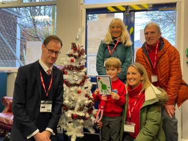 Tom Randall MP with the Ruari, age 5, holding the winning entry he designed alongside his mother and grandparents at Westdale Infant School.